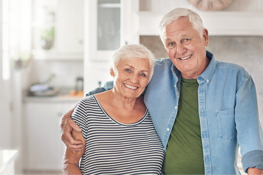 A couple holding each other by the kitchen counter A couple holding each other by the kitchen counter