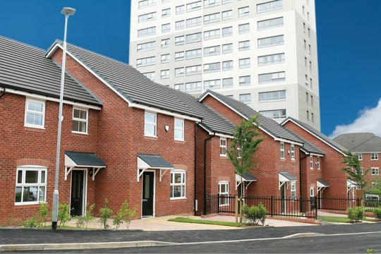 Four houses in a row with a black door with a high rise flat in the background Four houses in a row with a black door with a high rise flat in the background