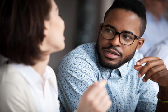 Man wearing glasses explaining something to a woman Man wearing glasses explaining something to a woman