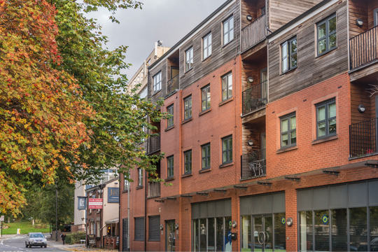 Property with wood and brick above some shops Property with wood and brick above some shops