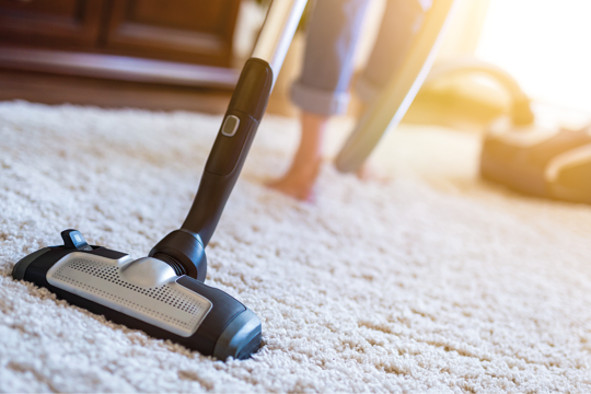 A woman hoovering her carpet A woman hoovering her carpet